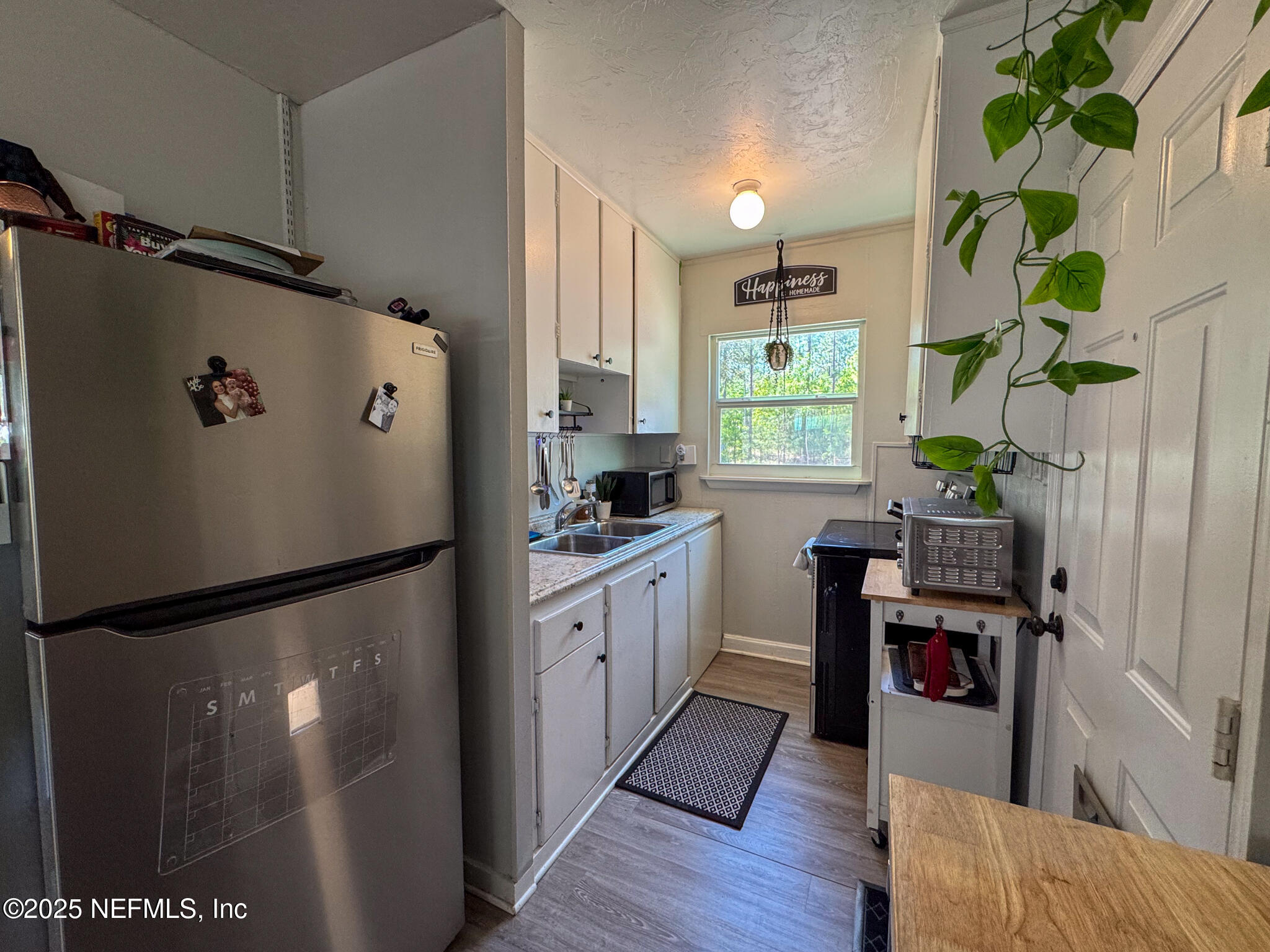 109 Mason Road Melrose, FL 32666 - Photo 10 of 27 a kitchen with stainless steel appliances a refrigerator and a wooden floor