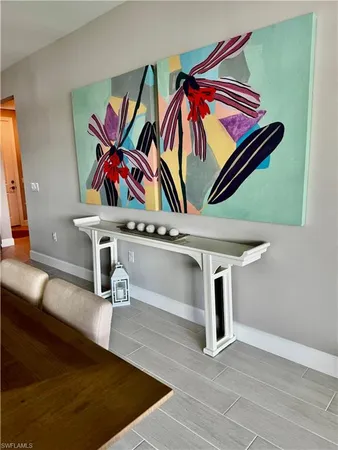 a living room with a table and paintings on the wall