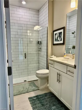 a bathroom with a granite countertop toilet sink and shower
