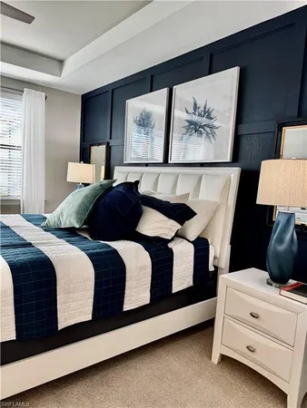 a bedroom with a bed lamp on wall and a large window