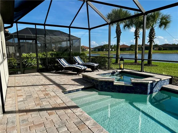 a view of a swimming pool with a table and chairs under an umbrella