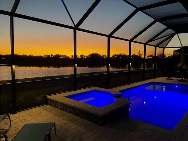 a view of swimming pool with a table and chairs under an umbrella