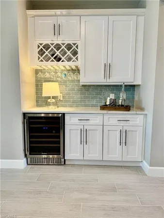 a kitchen with white cabinets and sink