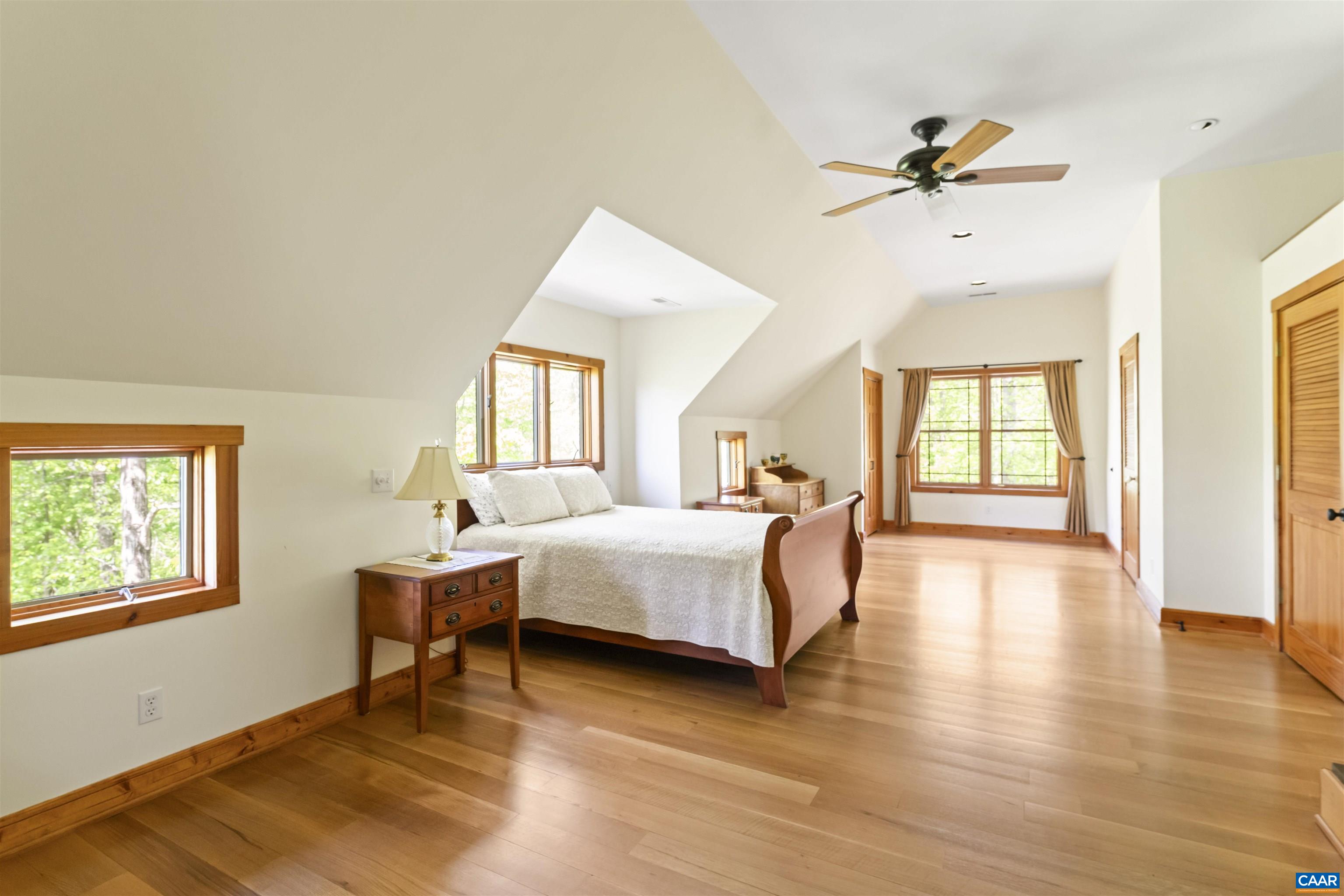 7530 Damon Road Schuyler, VA 22969 - Photo 26 of 72 a spacious bedroom with a bed a table and a chandelier