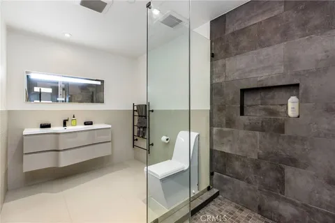 a bathroom with a double vanity sink a mirror and a shower