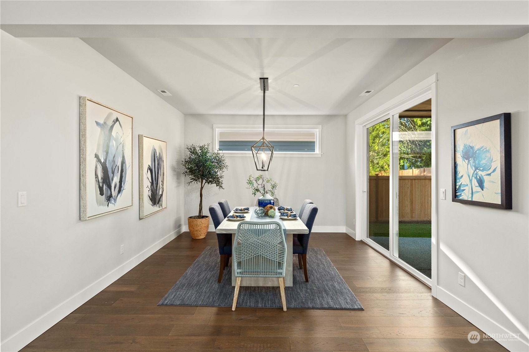 8711 240th Street Southwest Edmonds, WA 98026 - Photo 14 of 37 a dining room with wooden floor a chandelier a glass table and chairs