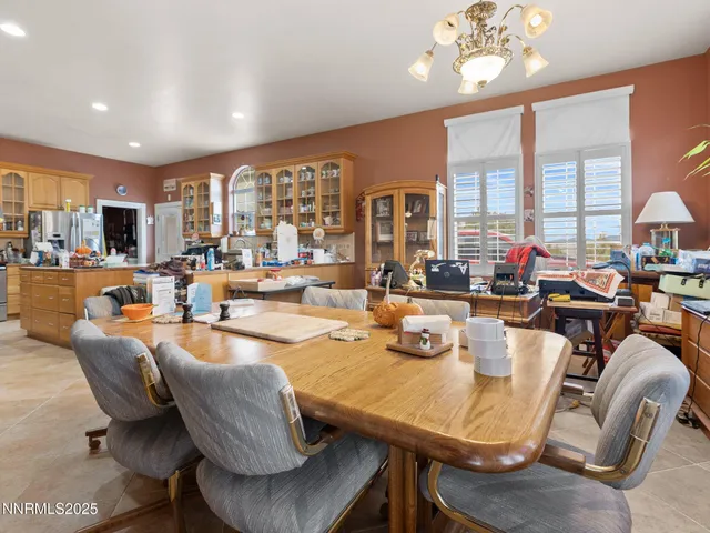 a dining room with furniture a large window and a chandelier