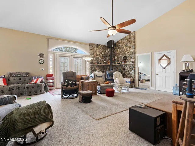 a living room with furniture a chandelier fan and a window