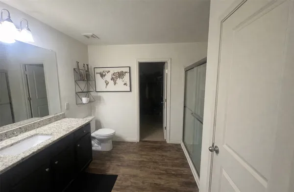 a bathroom with a granite countertop toilet sink and a mirror
