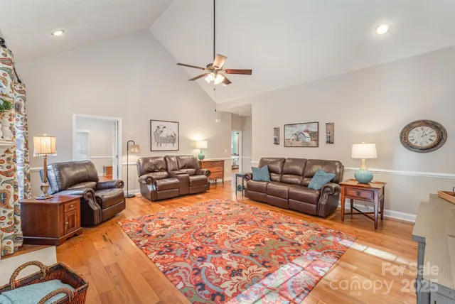 a living room with furniture kitchen view and a chandelier