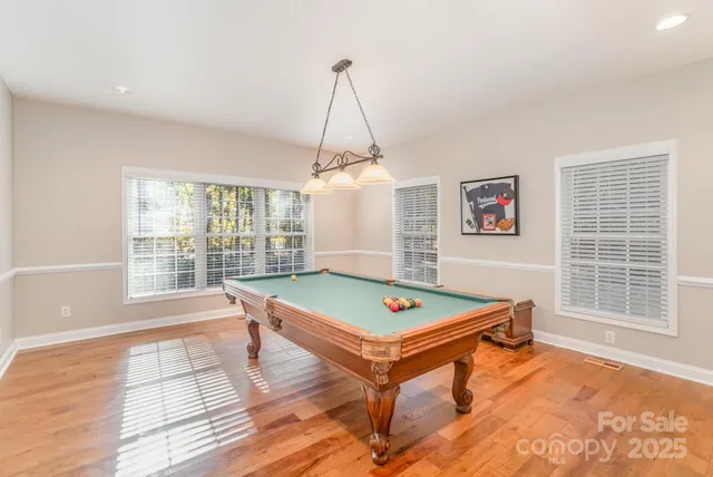 a room with pool table and windows