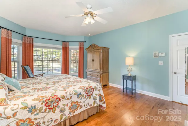 a bedroom with a large bed a chandelier and a window