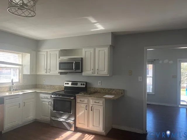 a kitchen with white cabinets stainless steel appliances and sink