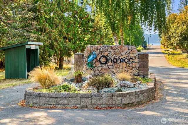 a view of a wooden house with large trees and plants