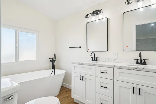 a bathroom with a toilet a sink a mirror and a bathtub