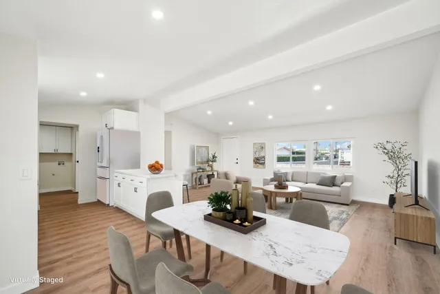 a living room with furniture and a dining table with kitchen view