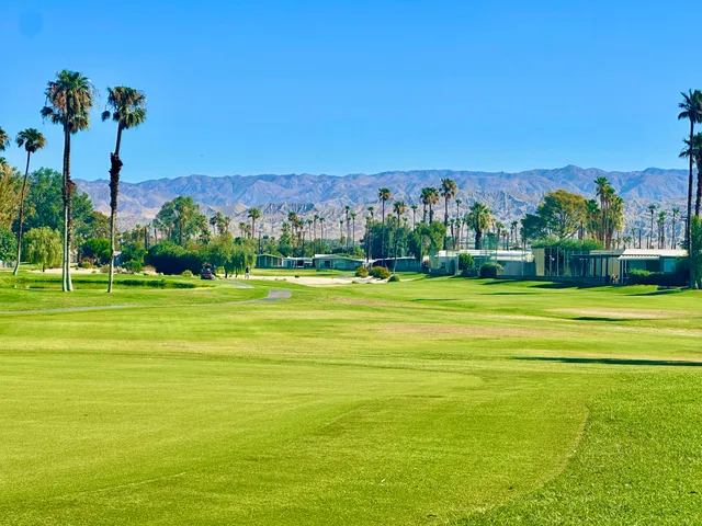 a living room with furniture a flat screen tv and kitchen view