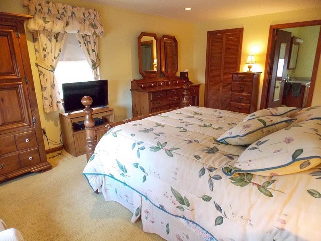 22 Lantern Lane Worcester, MA 01609 - Photo 20 of 32 a bedroom with a bed and dresser with mirror