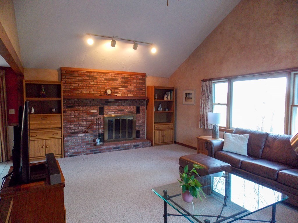 22 Lantern Lane Worcester, MA 01609 - Photo 5 of 32 a living room with furniture a fireplace and a flat screen tv