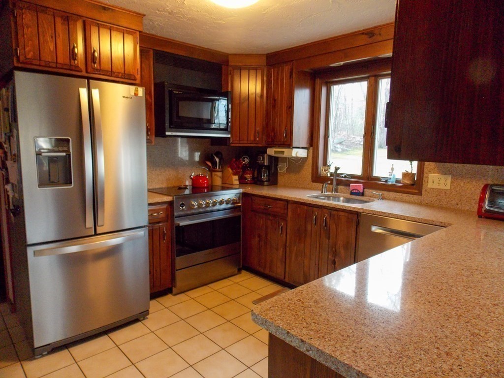 22 Lantern Lane Worcester, MA 01609 - Photo 7 of 32 a kitchen with stainless steel appliances granite countertop a refrigerator a sink dishwasher a stove top oven a refrigerator and island