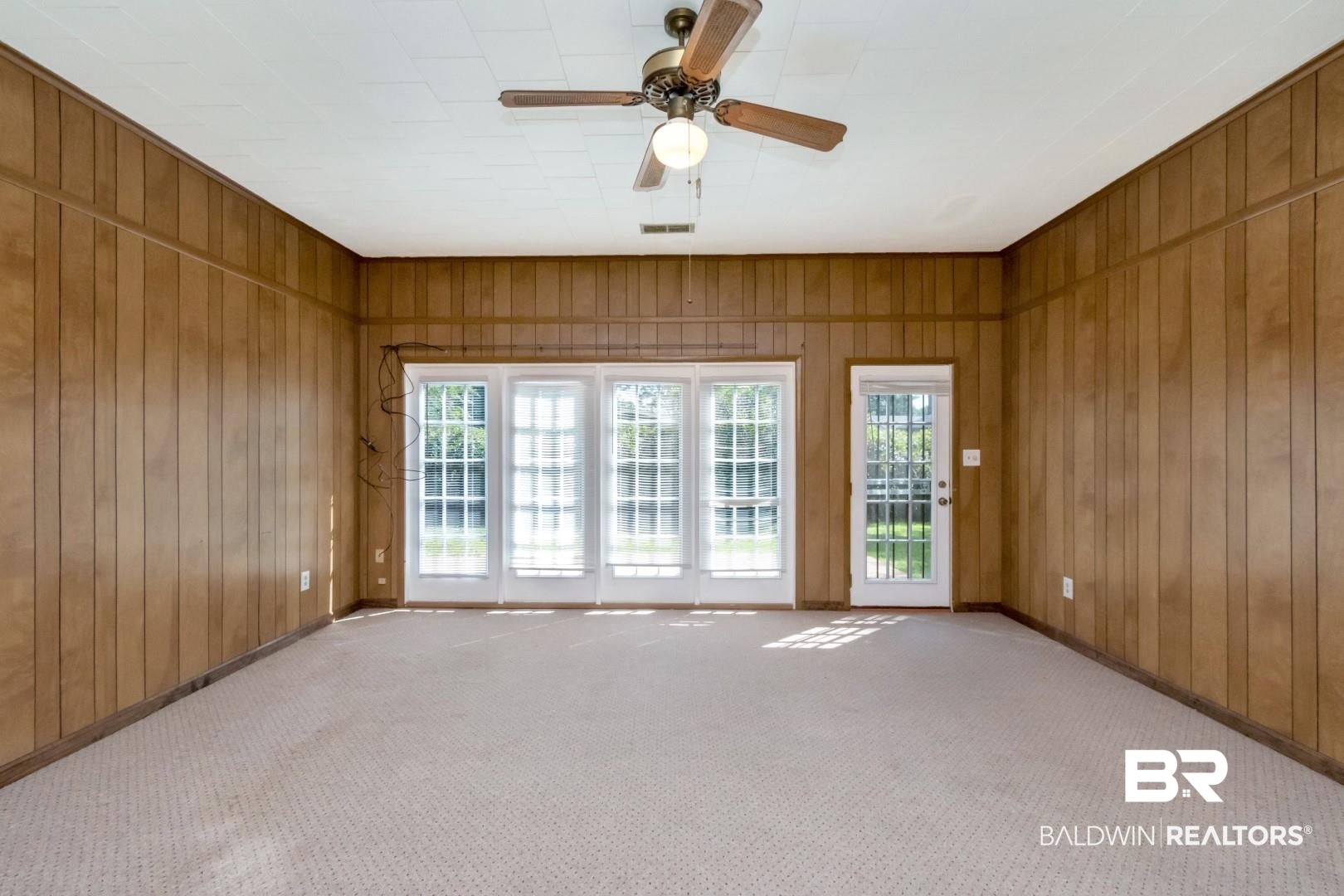 1477 Fairfield Street Mobile, AL 36606 - Photo 21 of 34 Empty room featuring carpet flooring, ceiling fan, and wood walls