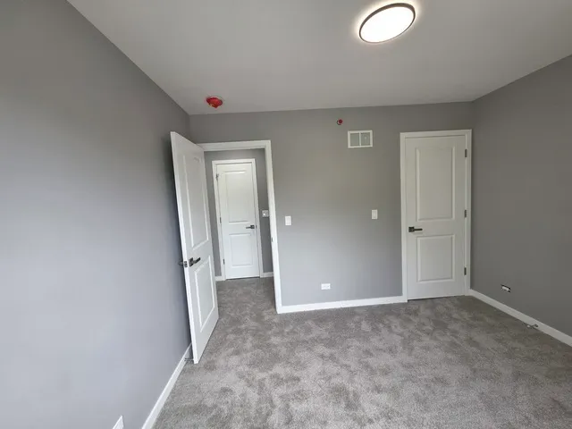 an empty room with closet and mirror