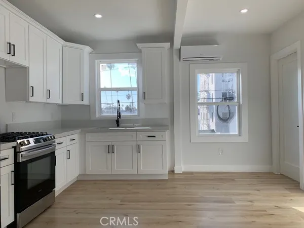 a kitchen with granite countertop a stove a sink and a microwave