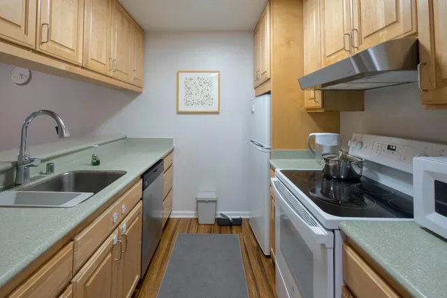 a kitchen with stainless steel appliances granite countertop a sink and a stove