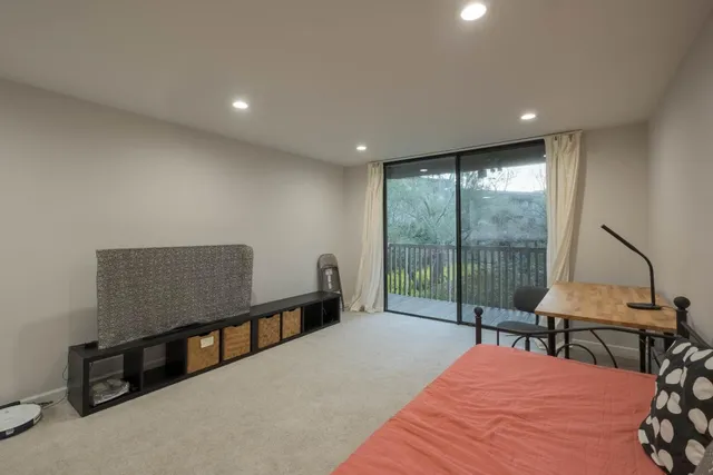 a bedroom with furniture and a large window
