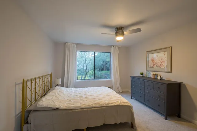 a bed sitting in a bedroom next to a window