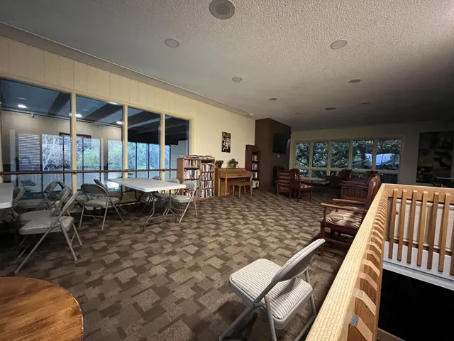 a living room with lots of furniture a rug and a view of kitchen