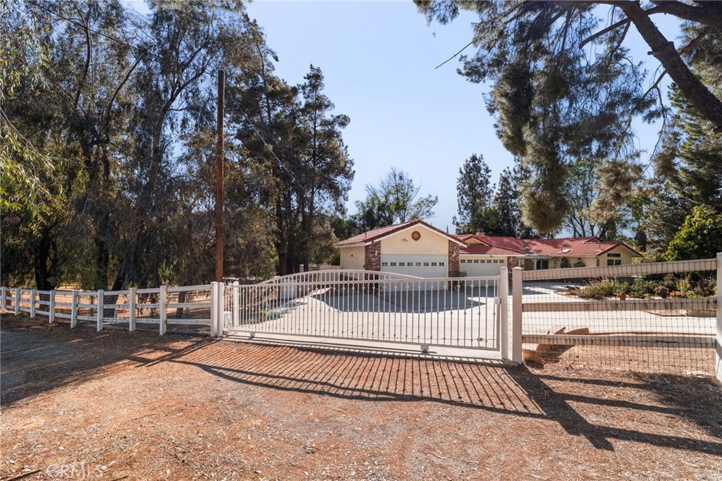16620 Rocky Glen Road Perris, CA 92570 - Photo 11 of 72 a view of a house with a small yard and large trees