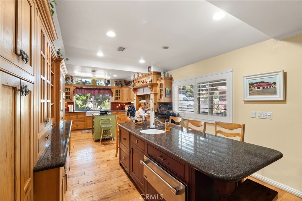 16620 Rocky Glen Road Perris, CA 92570 - Photo 15 of 72 a kitchen with stainless steel appliances granite countertop a sink dishwasher and a refrigerator with wooden floor