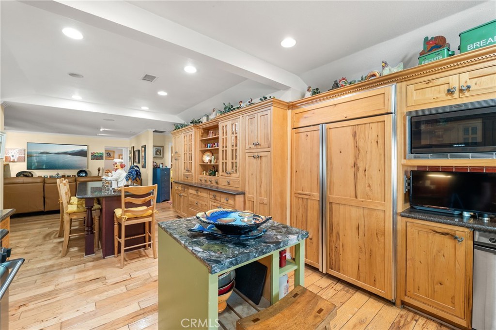 16620 Rocky Glen Road Perris, CA 92570 - Photo 19 of 72 a kitchen with stainless steel appliances granite countertop a stove refrigerator and a dining table with wooden floor