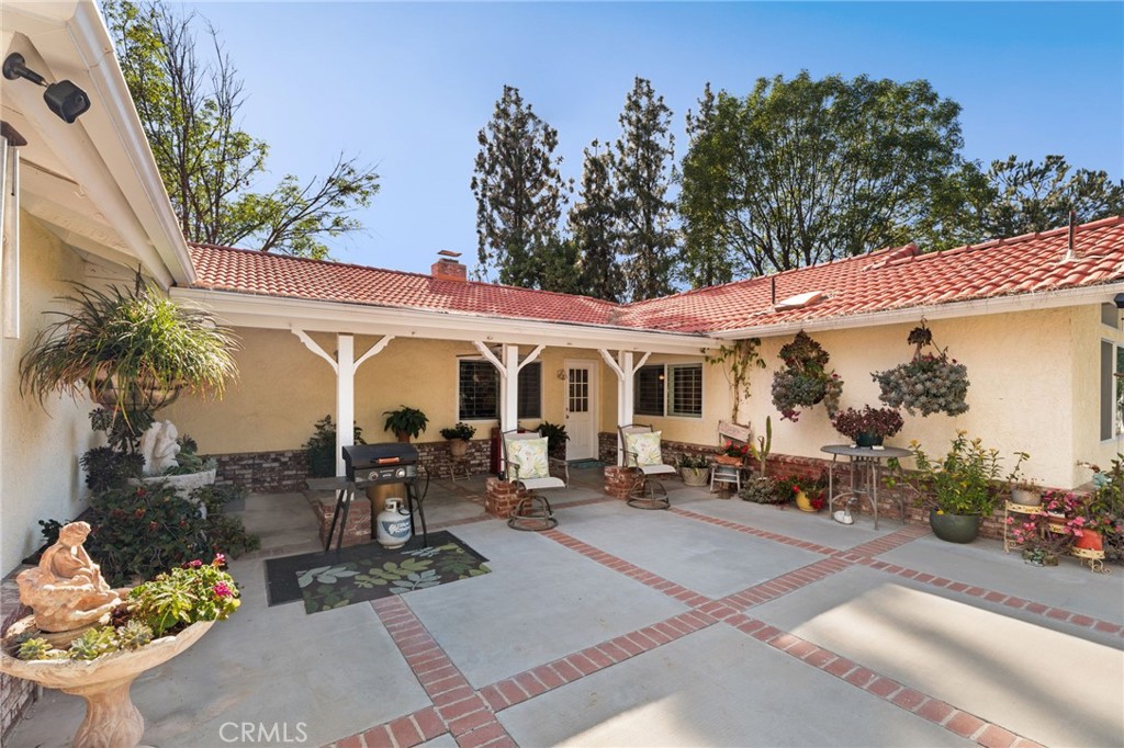 16620 Rocky Glen Road Perris, CA 92570 - Photo 37 of 72 a view of a patio with table and chairs potted plants and a palm tree