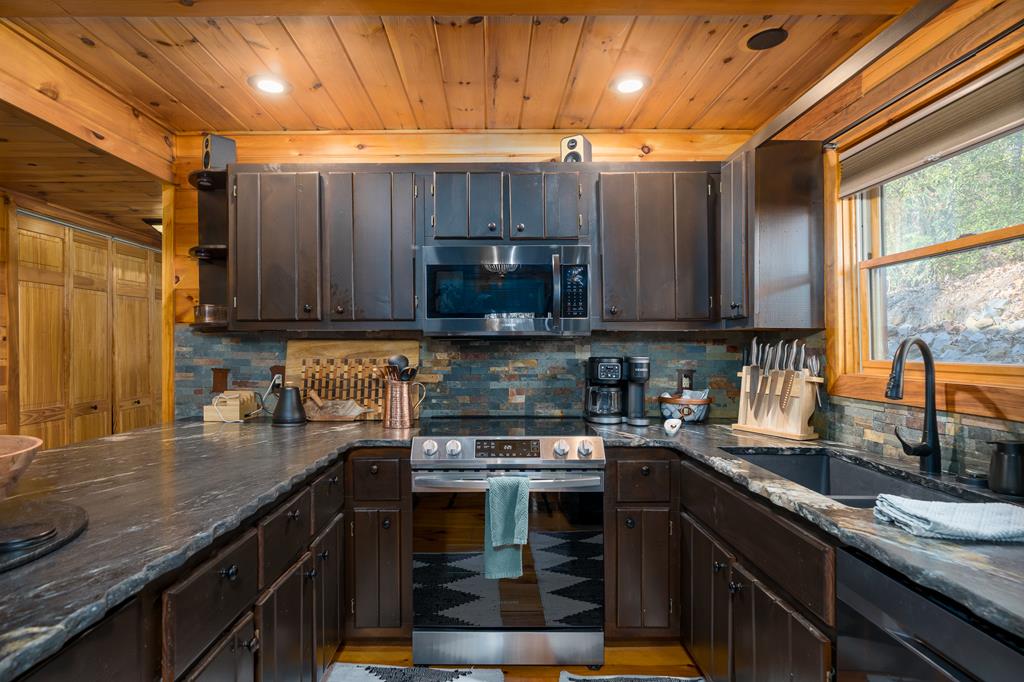 229 Ringtail Run Murphy, NC 28906 - Photo 16 of 68 a kitchen with granite countertop wooden cabinets and a stove top oven