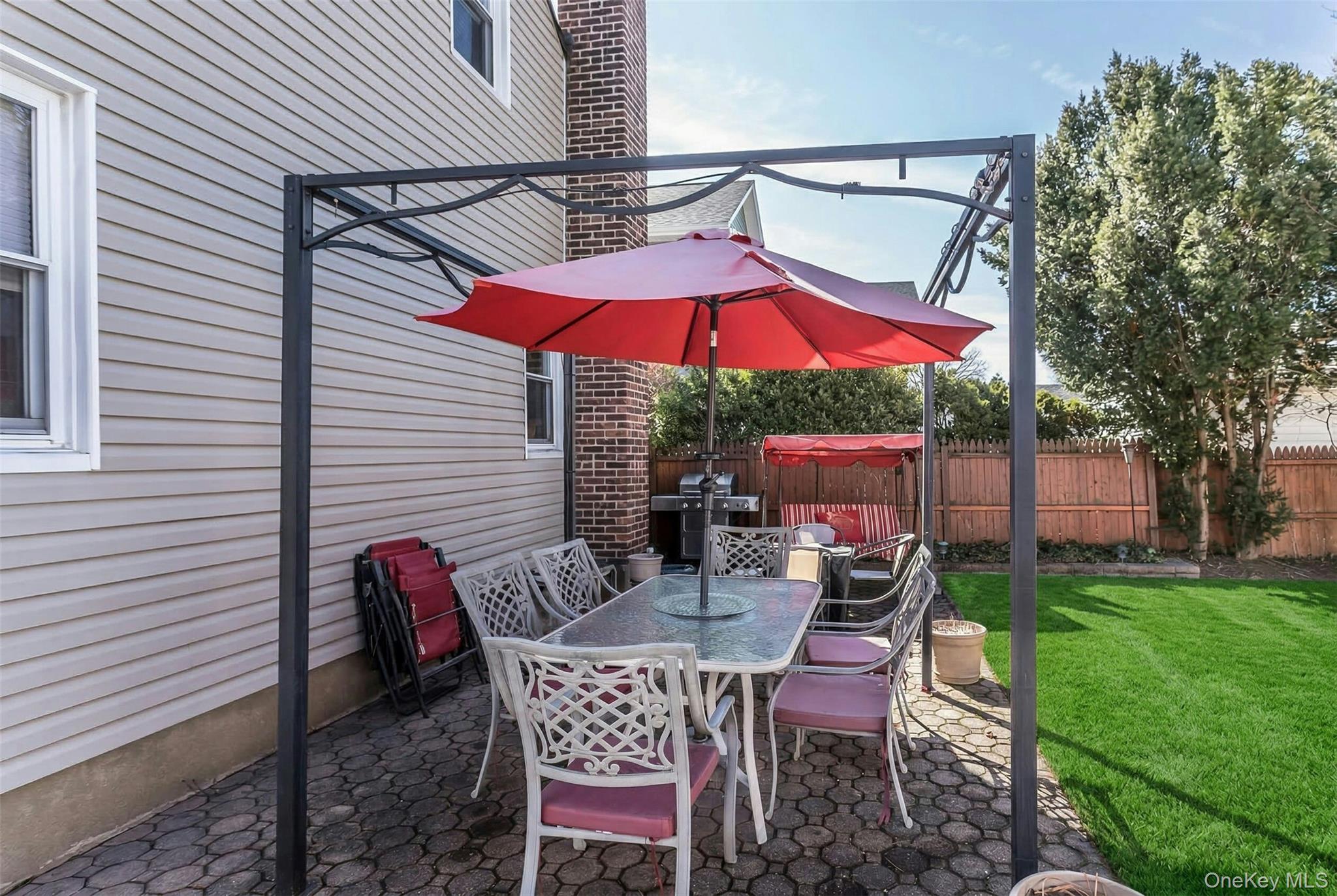 232 Ribbon Street Franklin Square, NY 11010 - Photo 16 of 19 a view of a patio with a table and chairs under an umbrella