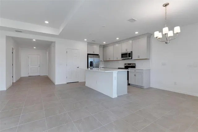 a view of a kitchen with center island and stainless steel appliances