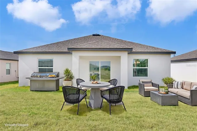 a view of a house with backyard sitting area and garden