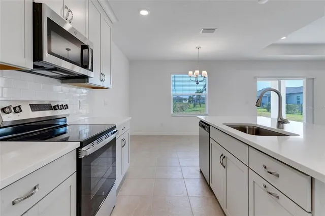 a kitchen with stainless steel appliances granite countertop a sink and a stove