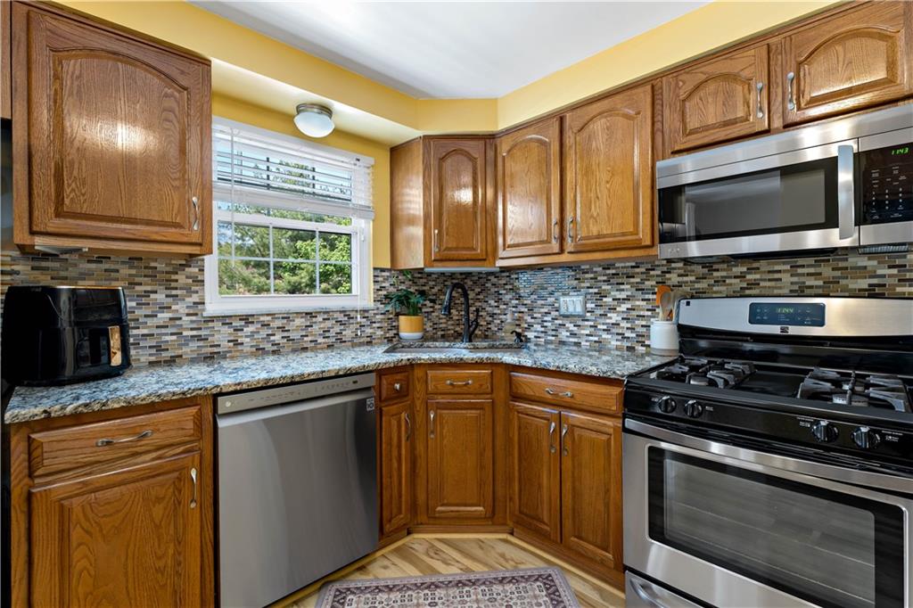 331 Trinity Drive Washington, PA 15301 - Photo 12 of 35 a kitchen with stainless steel appliances a stove a sink a microwave cabinets and a counter top space
