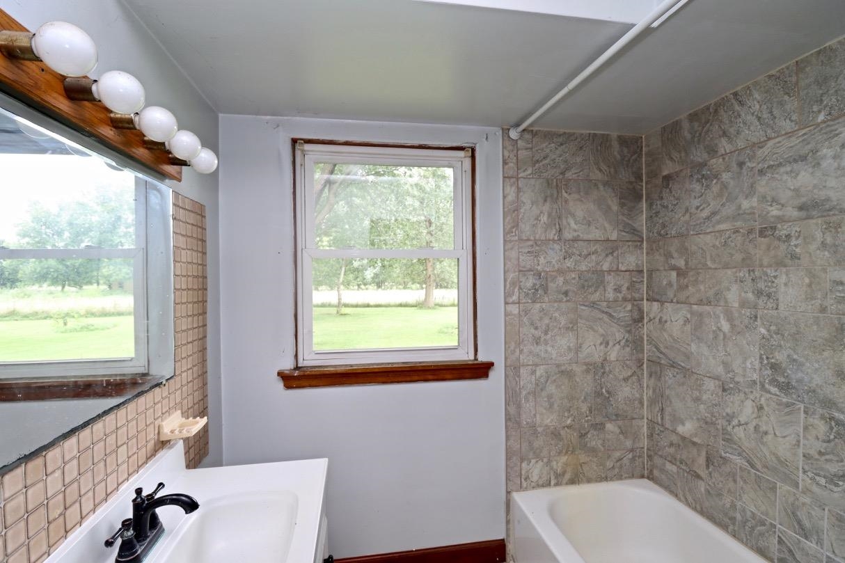 15262 Russellville Road Capron, IL 61012 - Photo 9 of 11 a bathroom with a granite countertop bathtub next to a window
