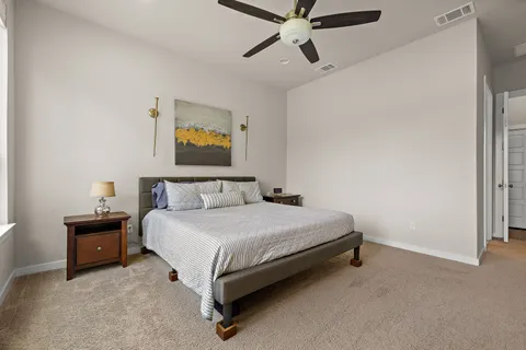 a spacious bedroom with a bed and a painting on the wall