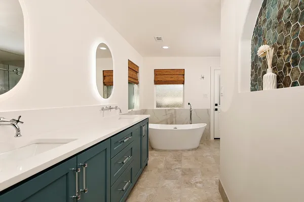 a spacious bathroom with a double vanity sink mirror and bathtub