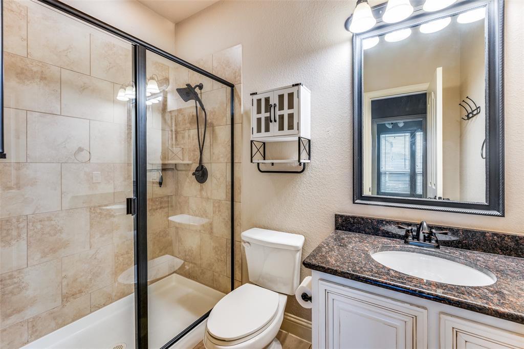 1137 Cardinal Ridge Road Burleson, TX 76028 - Photo 23 of 28 a bathroom with a granite countertop toilet sink and shower