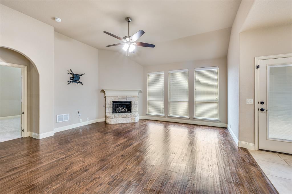 1137 Cardinal Ridge Road Burleson, TX 76028 - Photo 3 of 28 an empty room with wooden floor fireplace and windows