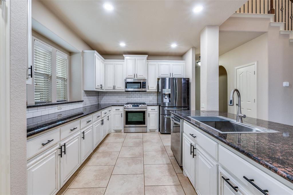 1137 Cardinal Ridge Road Burleson, TX 76028 - Photo 10 of 28 a large kitchen with stainless steel appliances granite countertop a sink and cabinets