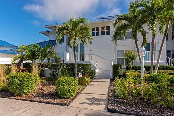 a front view of yellow house with a garden