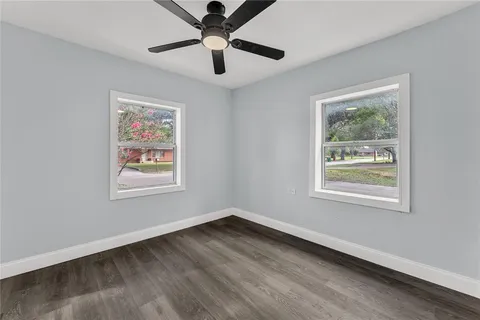 a view of an empty room with a window and a painting on the wall