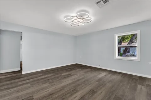 a view of a room with wooden floor and window